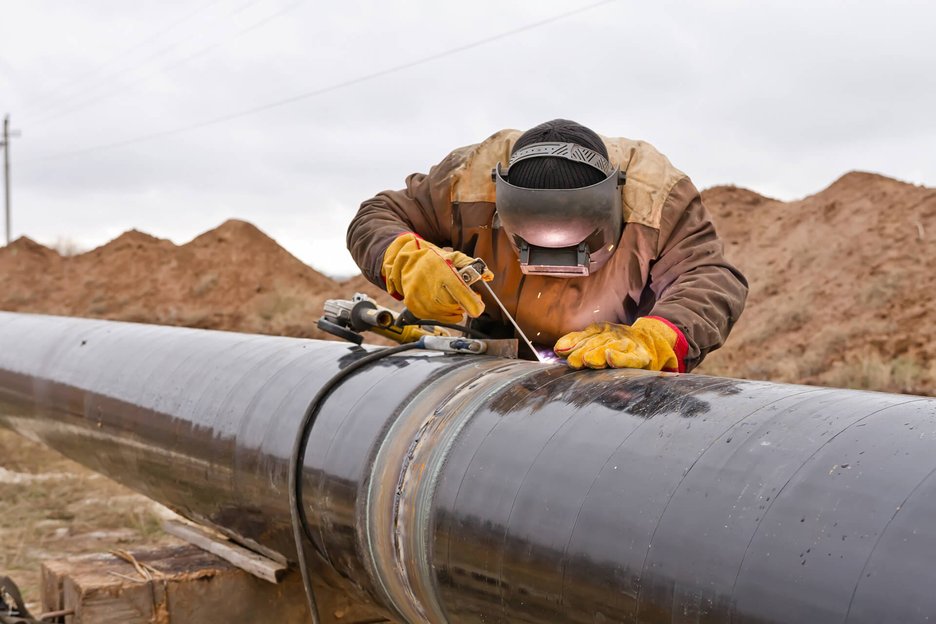 welder installing and repairing steel pipeline