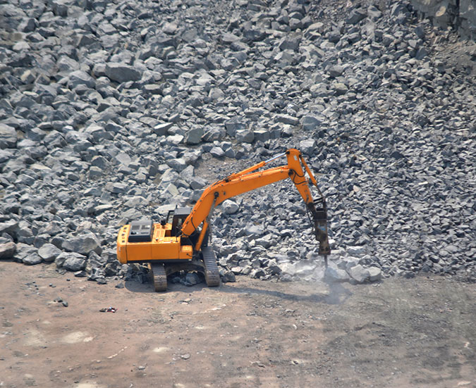 rock crusher machine in field full of rocks